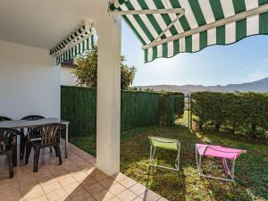 eine Terrasse mit einem Tisch, Stühlen und einem Zaun in der Unterkunft Appartement Hendaye, 2 pièces, 4 personnes - FR-1-2-414 in Irún