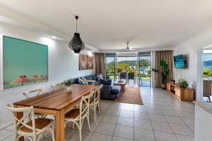 uma sala de jantar e sala de estar com mesa e cadeiras em Lagoon Apartments on Hamilton Island by HIHA em Hamilton Island