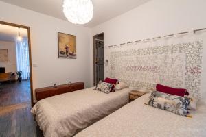 a bedroom with two beds and a chandelier at Appartement Grenat Bourg d'Oisans in Le Bourg-dʼOisans