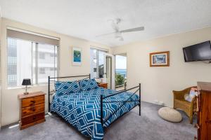 a bedroom with a bed and a tv and windows at Birdseye View Apartment at Nelson Bay in Nelson Bay