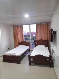- 2 lits dans une chambre avec fenêtre dans l'établissement Hotel Villa Grant, à Aguachica