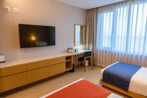 a hotel room with a bed and a desk with a television at Gwangyang Lacky Hotel in Gwangyang