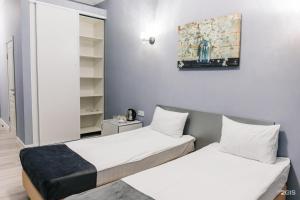 a room with two beds and a painting on the wall at RUSH BUTIK in Atyraū