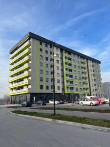 a large apartment building in a parking lot at Apartman 306 in Lukavica