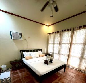 a bedroom with a bed and a ceiling fan at Casita Ysabel in Mabini