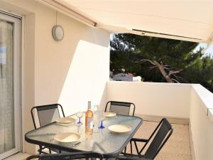 a glass table and chairs on a patio at Appartement Moderne avec Terrasse, Parking et Clim au Lavandou - 4 Couchages - FR-1-251-122 in Le Lavandou +11 photos