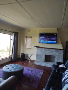 uma sala de estar com lareira e uma televisão por cima em Pumula Holiday Home em Hibberdene
