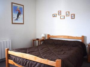een slaapkamer met een houten bed en een foto aan de muur bij Appartement Font-Romeu-Odeillo-Via, 3 pièces, 6 personnes - FR-1-580-34 in Font Romeu Odeillo Via