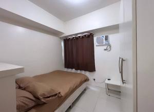 Sweden's Tiny Home, Studio Unit Condo في مانيلا: غرفة نوم صغيرة بها سرير ومغسلة