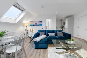 a living room with a blue couch and a table at Reading Town Centre 1 & 2 Bedroom Apartments with Parking by 360Stays in Reading