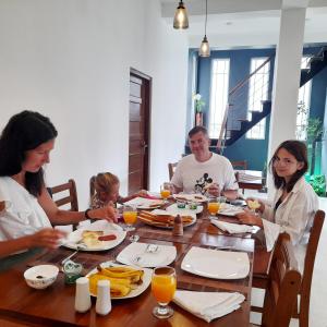 a family sitting around a table eating food at Pensive Villa in Nuwara Eliya