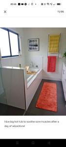a bathroom with a tub and a sink and a red rug at Seventeen Mc Bean Scenic Getaway in Boonah