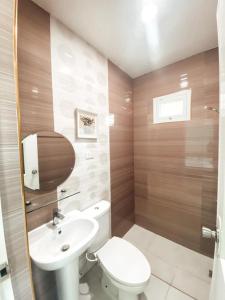 uma casa de banho com um WC branco e um lavatório. em Victoria's Garden and Event Center 