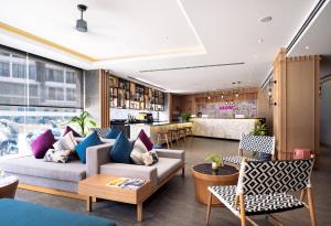 a living room with a couch and chairs and a bar at GLOW Mira Karon Beach in Karon Beach
