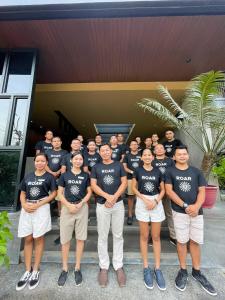 a group of people in t shirts posing for a picture at The Funny Lion - El Nido in El Nido