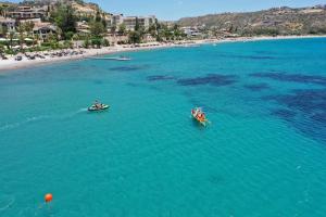 twee boten in het water naast een strand bij Horizon Pissouri Bay 1 bedroom apartment with communal pool in Pissouri