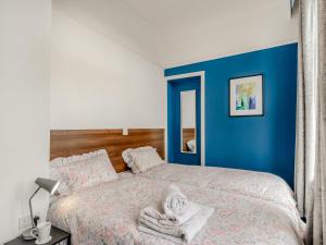 - une chambre avec des murs bleus et un lit avec des serviettes dans l'établissement Crossley Suite - Uk38334, à Halifax