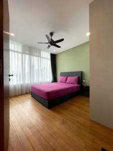 a bedroom with a pink bed and a ceiling fan at Vortex Suites KLCC by Fortune in Kuala Lumpur