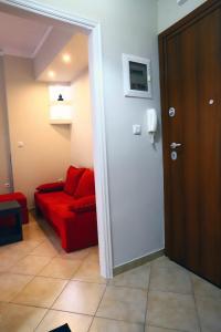 a living room with a red couch and a door at Ourania Apartment in Drama