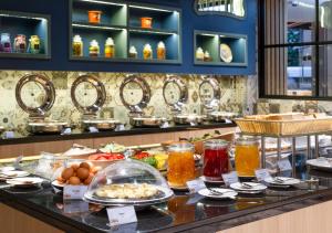 a buffet of food on a counter in a restaurant at GLOW Mira Karon Beach in Karon Beach