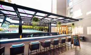 a bar with chairs and a pool in a building at GLOW Mira Karon Beach in Karon Beach