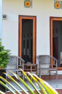 dwie ławki na ganku domu w obiekcie Maja House Penida w mieście Nusa Penida