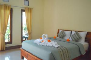 a bedroom with a bed with a flower on it at Maja House Penida in Nusa Penida