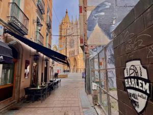an alley with tables and chairs and a building with a cathedral at Housingleon La Paloma in León