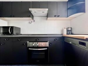 uma cozinha com armários pretos e um forno preto em Housingleon La Paloma em León