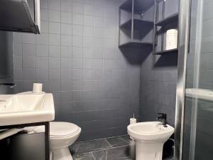 Un baño con un inodoro blanco y un lavabo. en Housing León La Paloma, en León