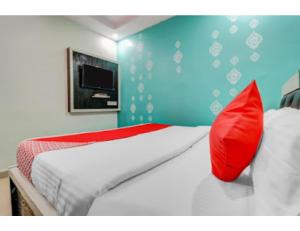 a bedroom with a bed with red and white pillows at Vishesh Resort, Lucknow in Lucknow