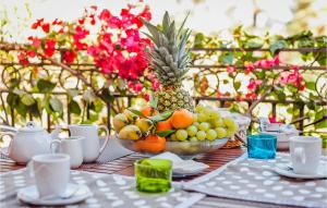 une table avec un bol de fruits et un ananas dans l'établissement Bilo 4, à Foxiʼe Sali
