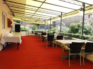 a room with tables and chairs on a red carpet at Rooms Tepli Bok in Primošten
