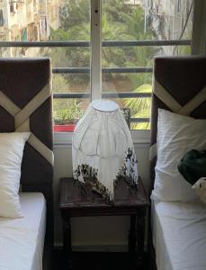 a lamp on a table next to two beds at Appartement calme et confort partagée in Casablanca