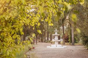 a fountain in the middle of a park with trees at Jaagir Manor, Dudhwa - IHCL SeleQtions in Paliā Kalān