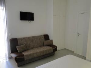a living room with a couch and a television on the wall at Rooms Tepli Bok in Primošten