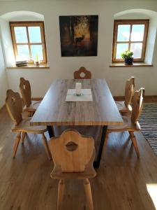 Appartement Fischl في ينباخ: طاولة خشبية كبيرة عليها كراسي وكوب قهوة
