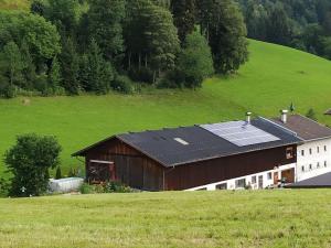 un granero con paneles solares en su techo en un campo en Appartement Fischl en Jenbach