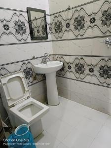 La salle de bains est pourvue de toilettes et d'un lavabo. dans l'établissement Rudraksha Hotel & Restaurant By WB Inn, à Rāmnagar