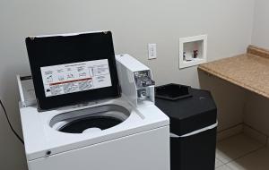 a washing machine with a tablet on top of it at Red Roof Inn & Suites Longview in Longview