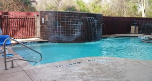 uma pequena piscina com queda de água em Red Roof Inn & Suites Longview em Longview