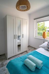 a bedroom with a bed with blue sheets and a window at Turkusowy Klif in Jastrzębia Góra