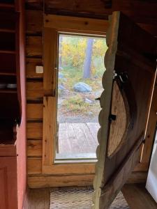 eine offene Tür zu einem Zimmer mit Fenster in der Unterkunft Elämyksellinen huvila Tuurujärven rannalla. in Ulvila