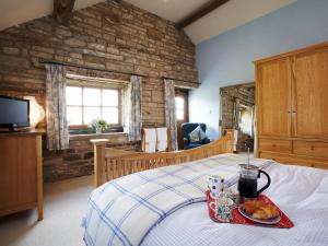 a bedroom with a bed with a tray of food on it at Rowan Cottage - Uk4187 in Hazlehead Bridge