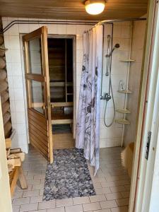 a bathroom with a shower and a shower curtain at Elämyksellinen huvila Tuurujärven rannalla. in Ulvila