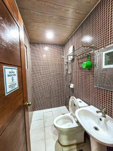a bathroom with a toilet and a sink at Hotel Urban in Baguio