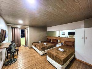 a large room with two beds and a desk at Hotel Urban in Baguio