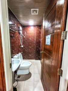 a bathroom with a toilet and a sink at Hotel Urban in Baguio