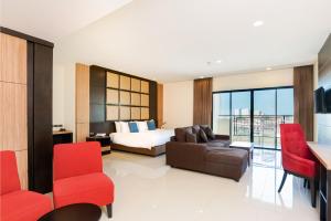 Grand Palazzo Hotel - SHA Extra Plus في باتايا سنترال: غرفه فندقيه بسرير واريكه وكراسي