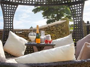 una mesa con una botella de vino y copas. en Rowan Cottage - Uk4187 en Hazelhead